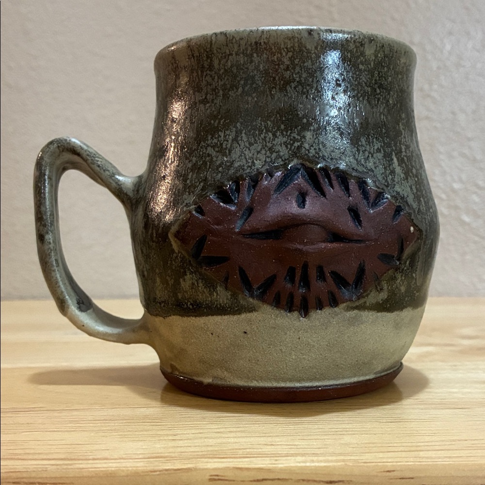 Handcrafted mug with eye on it. Red clay green and grey glaze No signature
